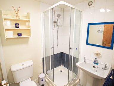 A bathroom with a shower cubicle toilet sink and mirror at Hafan Cottage in Beddgelert