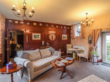 A sitting room with a sofa a coffee table two chairs and decorative plates on a wall at The Barn in Middleton near Ponteland