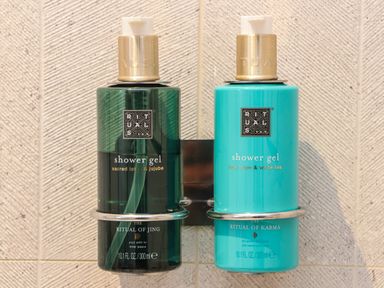 Two bottles of Rituals shower gel mounted on a wall with textured tiles at 31 Cliff Edge in Newquay
