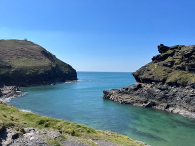 A coastal view with rocky cliffs and clear blue water at Harbour Light in Boscastle