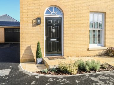 A front door with the number 23 on a yellow brick house with plants by the doorstep at The Hollies in Norwich