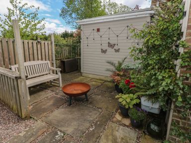 A garden with a bench, fire pit, and potted plants at Garden View in Pembroke