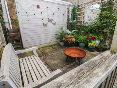 A garden with a bench and a fire pit surrounded by potted plants at Garden View in Pembroke