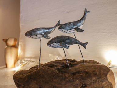 A wooden base with three metal whale sculptures at Lythe Cottage in Lythe