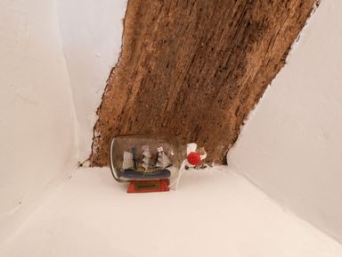 A model ship in a glass bottle placed on a wooden beam at Lythe Cottage in Lythe