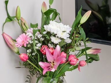 A bouquet of pink, white, and green flowers in a glass vase near a television at Apt 3 @ Hunter's Quay in Bridlington