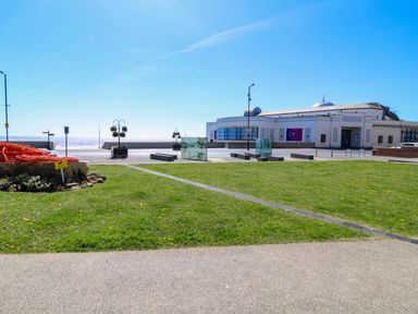 A view of the sea with grass and a building at Apt 3 @ Hunter's Quay, Bridlington