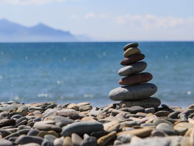 A beach with pebbles and a stack of stones by the sea at 5 The Crescent in Caernarfon