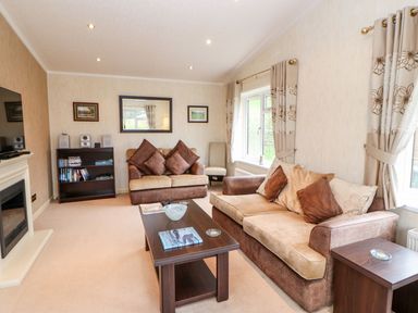 A living room with sofas coffee table bookshelf and fireplace at The Fairhaven in Tunstall near Catterick North Yorkshire