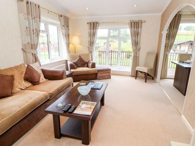 A living room with sofas chairs coffee table and large windows at The Fairhaven in Tunstall near Catterick North Yorkshire