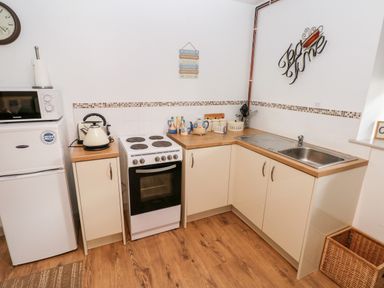 A kitchen with a refrigerator microwave stove kettle sink and cabinets at Barn 3 in Cwm-twrch Isaf near Ystradgynlais