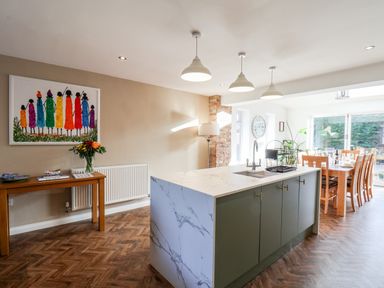 A kitchen with an island sink and dining table with chairs at Meadowfields in Whitby