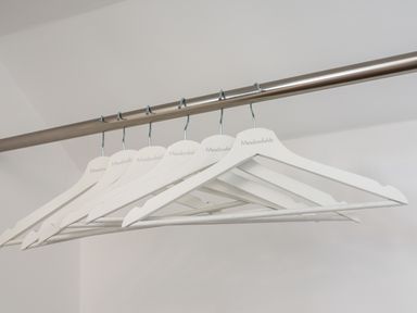 A row of white wooden hangers on a metal rod at Meadowfields in Whitby