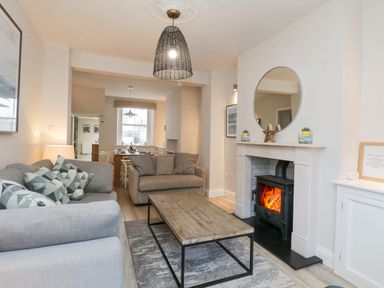 A living room with two sofas a wooden coffee table and a fireplace at Forty Five in Keswick