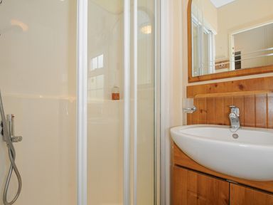 A bathroom with a shower enclosure and a washbasin with a mirror at Little Malory in St Giles-On-The-Heath