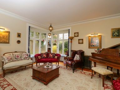 A living room with a piano and seating at White House