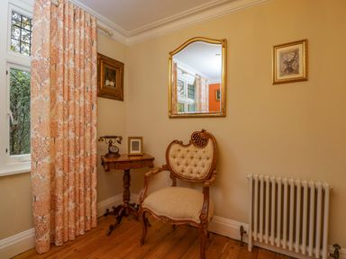 A sitting room with a chair and mirror at White House