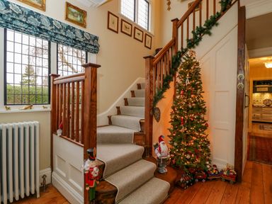 A hallway with a staircase and a Christmas tree at White House in 