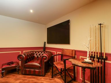 A snug with a leather sofa and pool cues at White House