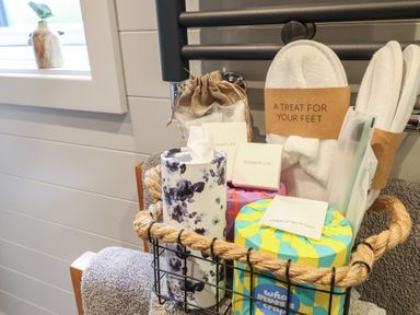 A bathroom with toiletries organized in a basket on a towel rack at Yes Deer in Ashbourne