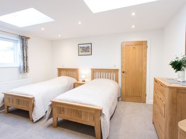 A bedroom with two single beds and a wooden dresser at Cornish Views in Camborne