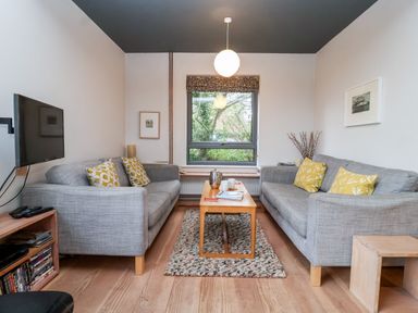 A living room with two sofas and a coffee table by a window at Mundays in Orford