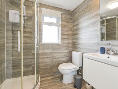 A bathroom with a glass shower enclosure toilet and a sink with a mirror at Lilys Pad in Okehampton