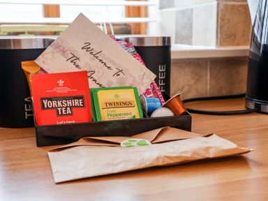 A kitchen counter with tea bags coffee pods and a welcome card at Guillemot in Flamborough