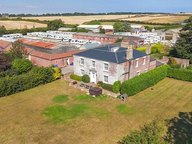A house with a garden and caravan park in the background at Guillemot in Flamborough