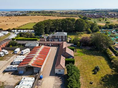 An aerial view of a property with caravans and fields at The Pheasantry in Flamborough