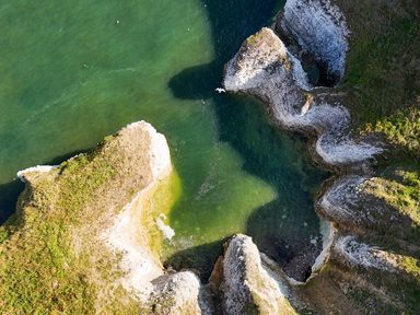 An aerial view of a coastline with rocks and water at The Pheasantry in Flamborough