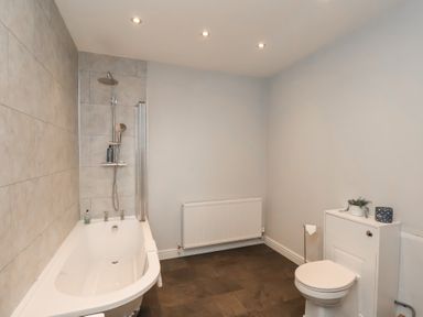 A bathroom with a bathtub, toilet, and shower at The Pheasantry in Flamborough