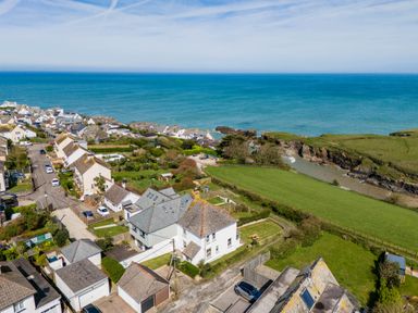 A coastal village with houses roads grassy fields and ocean at Tamarama House in Port Isaac