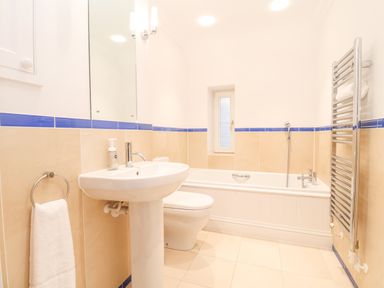 A bathroom with a pedestal sink toilet bathtub and towel rack at 9 Church Farm Rise in Aldeburgh