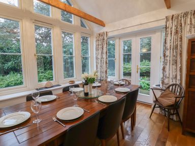 A dining room with a table set for dinner at 9 Church Farm Rise in Aldeburgh