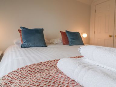 A bedroom with a bed and pillows at 9 Church Farm Rise Aldeburgh