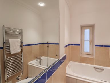A bathroom with a bathtub and towel radiator at 9 Church Farm Rise Aldeburgh