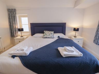 A bedroom with a bed and nightstands at 9 Church Farm Rise Aldeburgh
