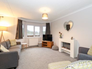 A living room with sofas television and a fireplace at Hill Lodge in Applethwaite 2 Limefitt Park near Windermere