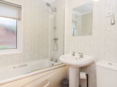 A bathroom with a bathtub shower combination sink and toilet at Hill Lodge Applethwaite 2 Limefitt Park near Windermere