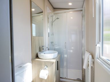 A bathroom with a toilet sink shower and towel rack at 11A Mansion View in Cove near Kilcreggan