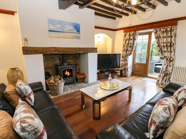 A living room with a fireplace television two sofas and a coffee table at Winding Wheel Cottage in Cambois near Ashington