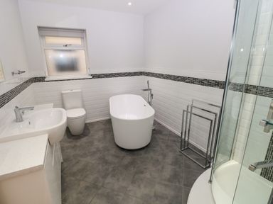 A bathroom with a bathtub toilet sink and shower at Llygad Yr Haul Sun in Burry Port