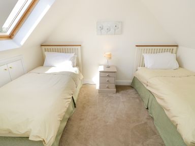 A bedroom with two single beds separated by a bedside table with a lamp at Little Owl Barn in Upton Snodsbury