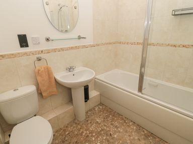A bathroom with a toilet sink bathtub and a towel at Little Tern in Seahouses