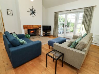 A living room with a fireplace and television at Little Tern Seahouses
