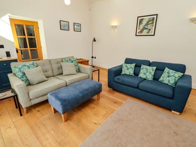 A living room with two sofas and an ottoman at Little Tern in Seahouses