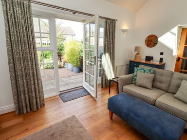 A living room with a sofa and ottoman at Little Tern Seahouses