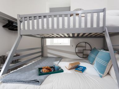 A bunk bed with breakfast tray and books in a bedroom at Chy Lowen in Porthleven