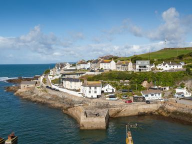 A coastal village with houses on rocky cliffs by the sea at Chy Lowen in Porthleven